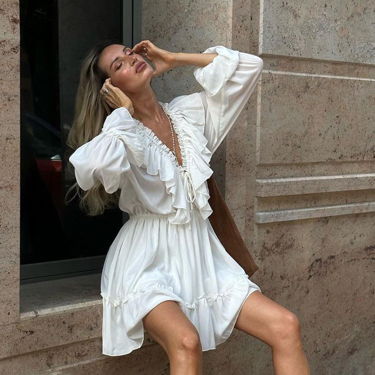 Vestido blanco con volantes, mangas acampanadas, escote en V y pliegues