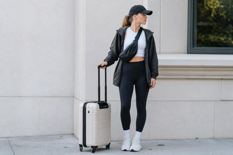Athleisure capsule wardrobe essentials laid out: leggings, joggers, hoodie, sneakers, and belt bag in neutral tones