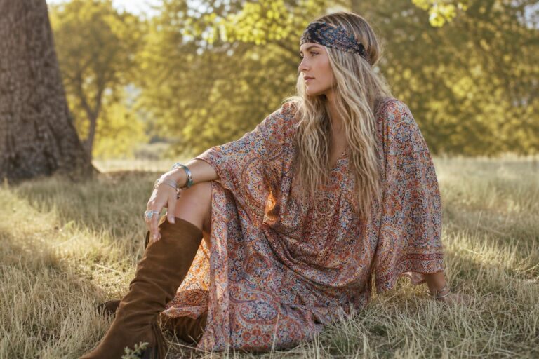 Woman in hippie style clothing wearing a paisley maxi dress and peasant blouse with fringe bag on a city street