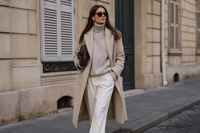 Winter outfits capsule wardrobe with wool coat, turtleneck, tailored trousers, ankle boots, leather gloves, and long scarf on a city street