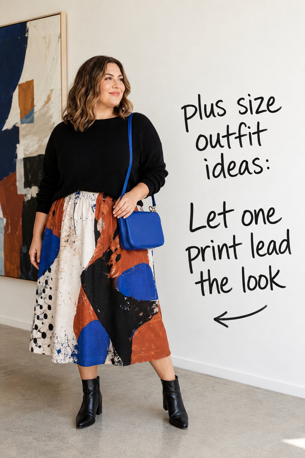 plus size outfit ideas with a printed midi skirt, black knit, boots, and blue bag